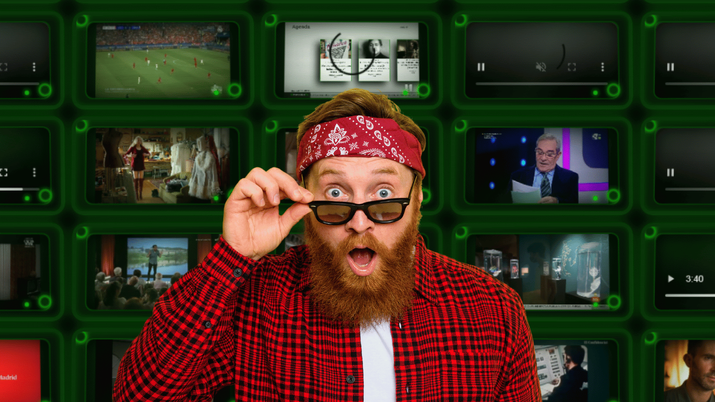 Un hombre muy sorprendido delante de un fondo de pantallas de televisión