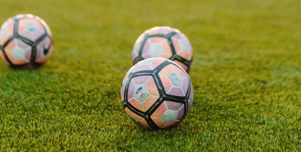 Tres pelotas de fútbol sobre un campo