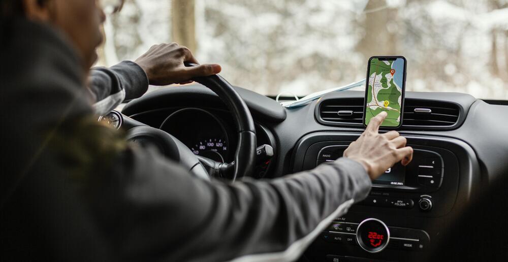 martphone colocado en un soporte de rejilla de ventilación de un coche, ilustrando el método de refrigeración mediante el aire acondicionado