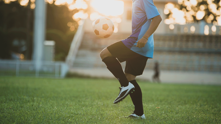 Vista lateral de un jugador de fútbol controlando un balón