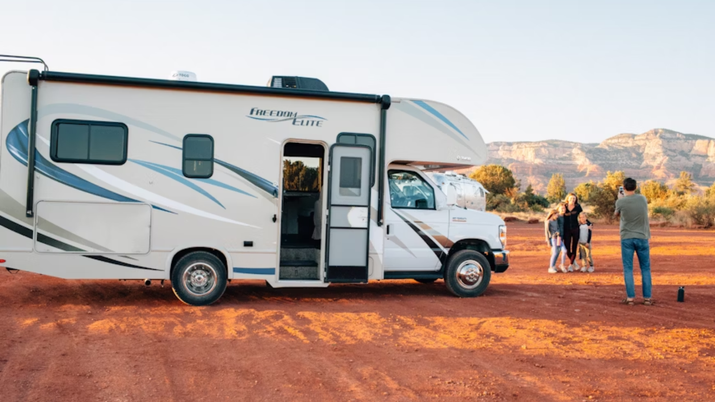 imagen autocaravana con familia al lado sacándose foto