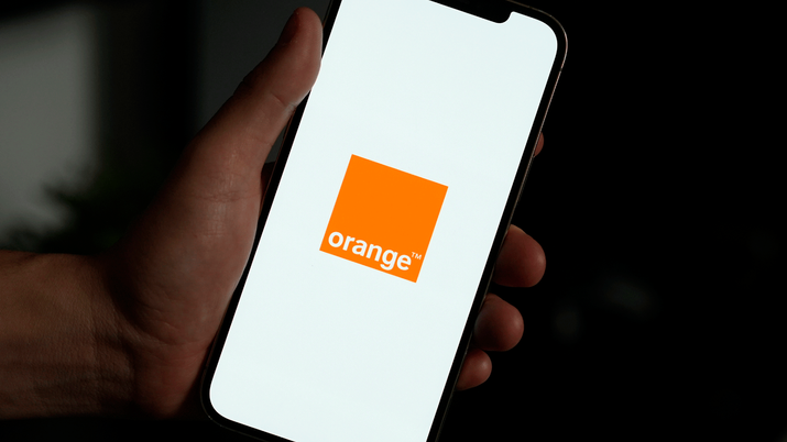 Smartphone mostrando la aplicación Mi Orange junto a un icono de señal WiFi, representando el servicio WiFi Premium para optimizar la red del hogar