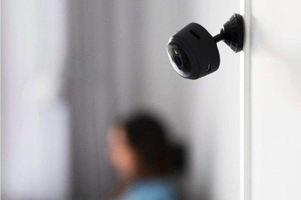 Cámara de seguridad tipo domo instalada en el techo de un salón, vigilando el interior de una vivienda particular