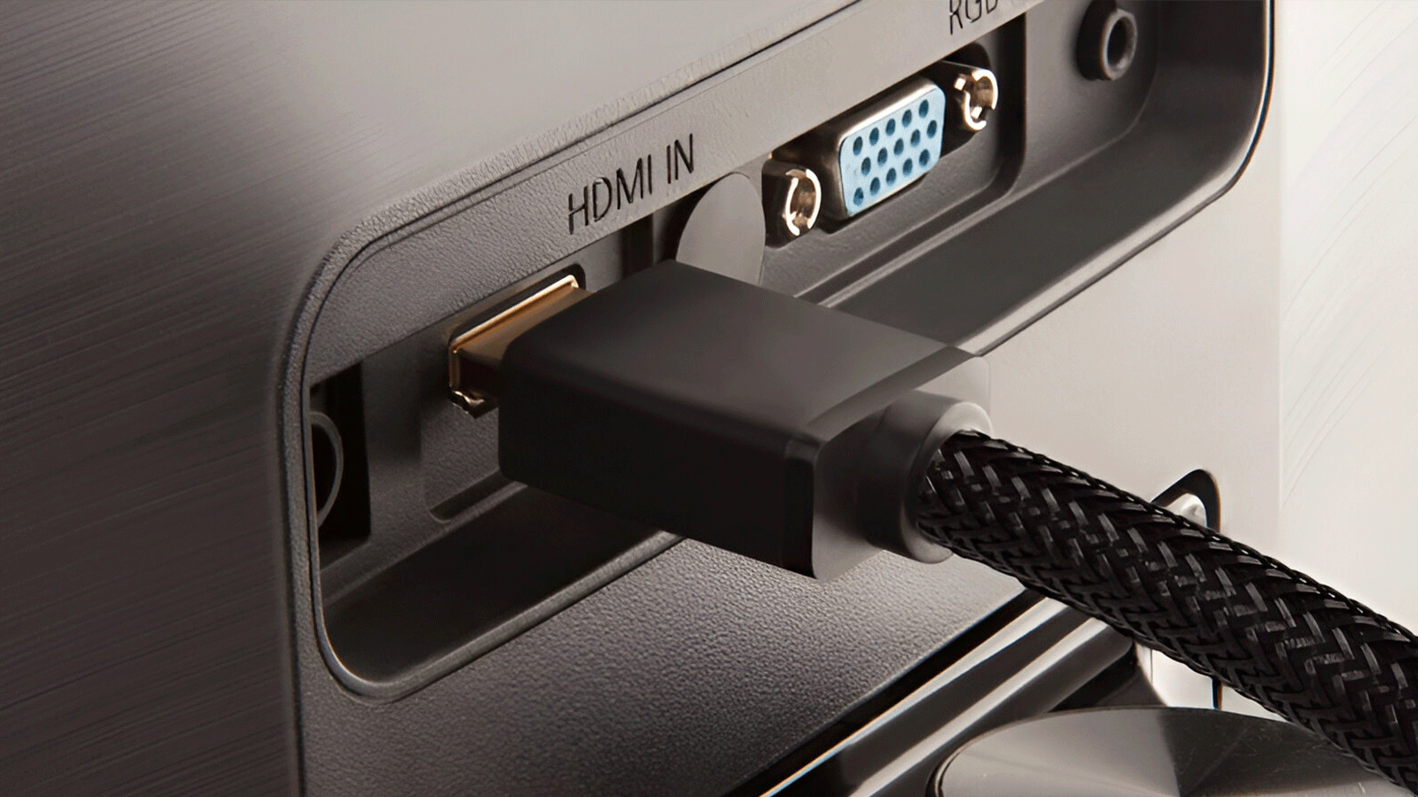 Mano de una persona conectando un cable HDMI certificado de alta velocidad al puerto ARC de una Smart TV LG