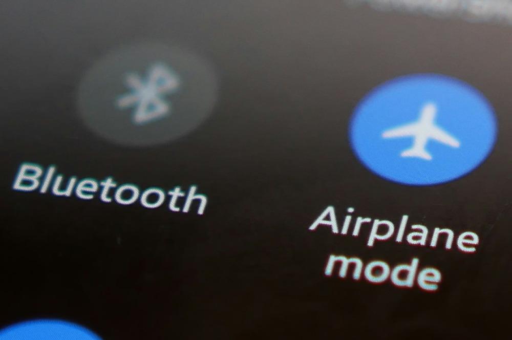 Captura de pantalla del menú de ajustes rápidos de un móvil Android, con el dedo a punto de pulsar el icono del Modo Avión para activarlo