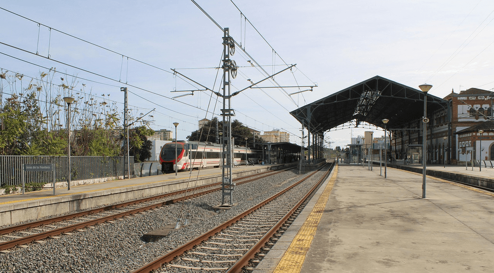 Una estación de Renfe con un tren al fondo