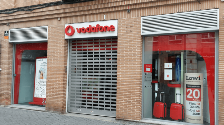 Fachada de una tienda comercial de Vodafone en una calle céntrica, con el logotipo rojo corporativo visible