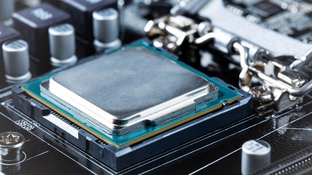 Primer plano de un procesador Intel Core siendo instalado en el zócalo de una placa base, destacando el componente central afectado por la vulnerabilidad Plundervolt