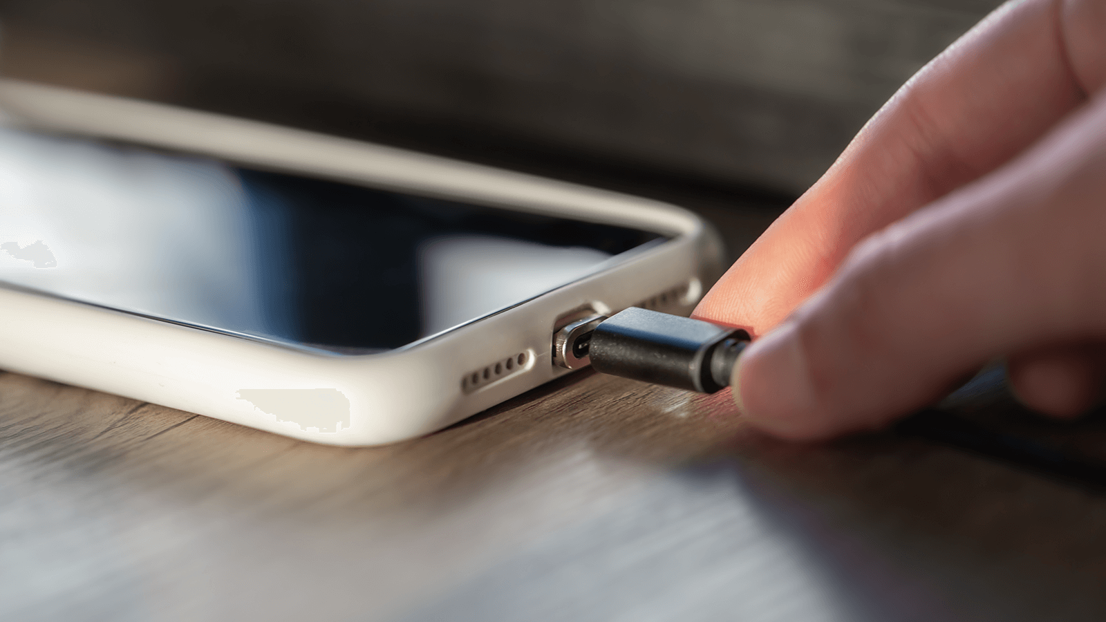 Hub adaptador USB-C multifunción de color gris conectado a un smartphone, mostrando cómo expande la conectividad con puertos HDMI, USB-A y lector de tarjetas