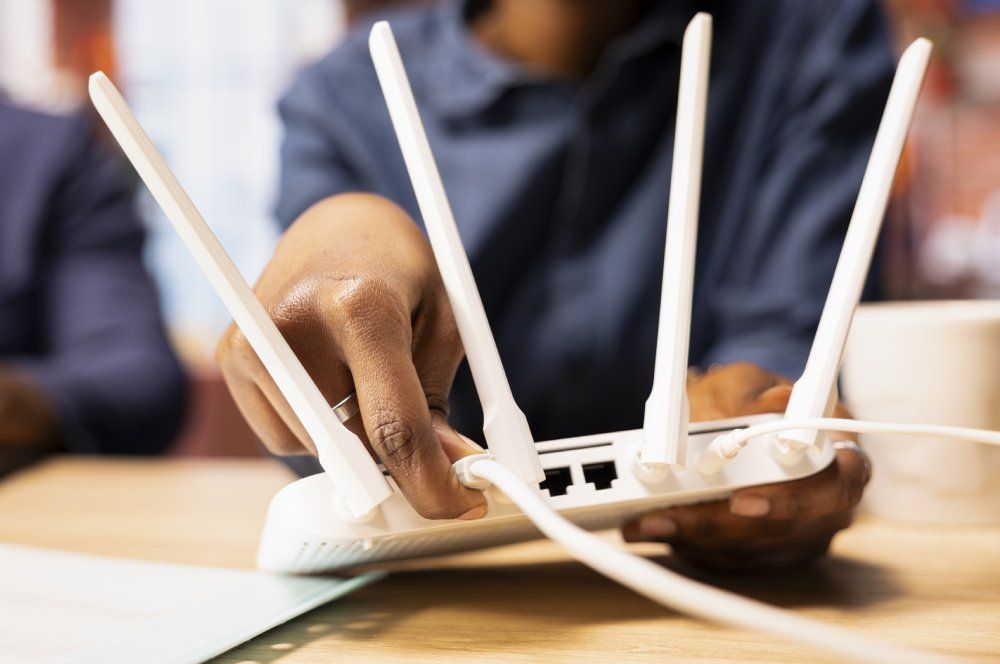 Una mujer conectando el cable de Ethernet al router