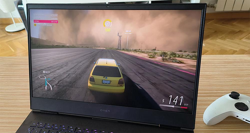 OMEN 16 de HP con Forza Motorsport Volkswagen Golf amarillo frente a tormenta de arena