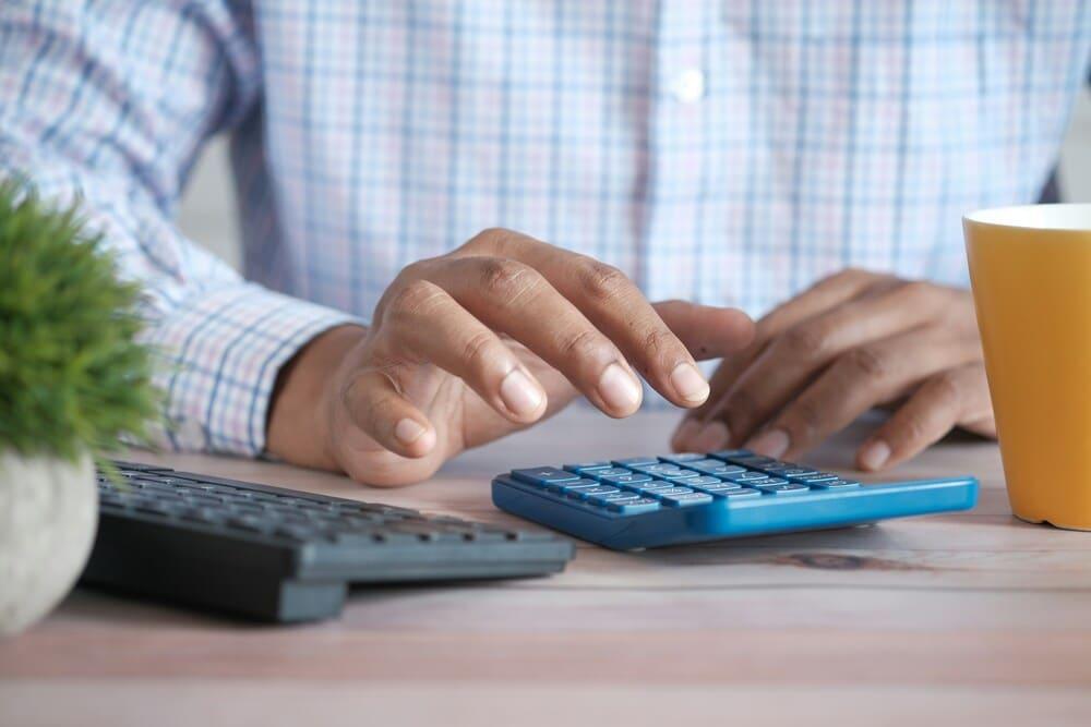persona con un ordenador y una calculadora