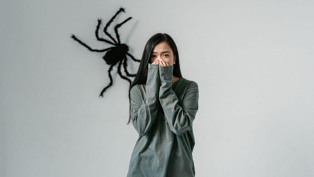 Chica joven asustada porque hay una araña detrás