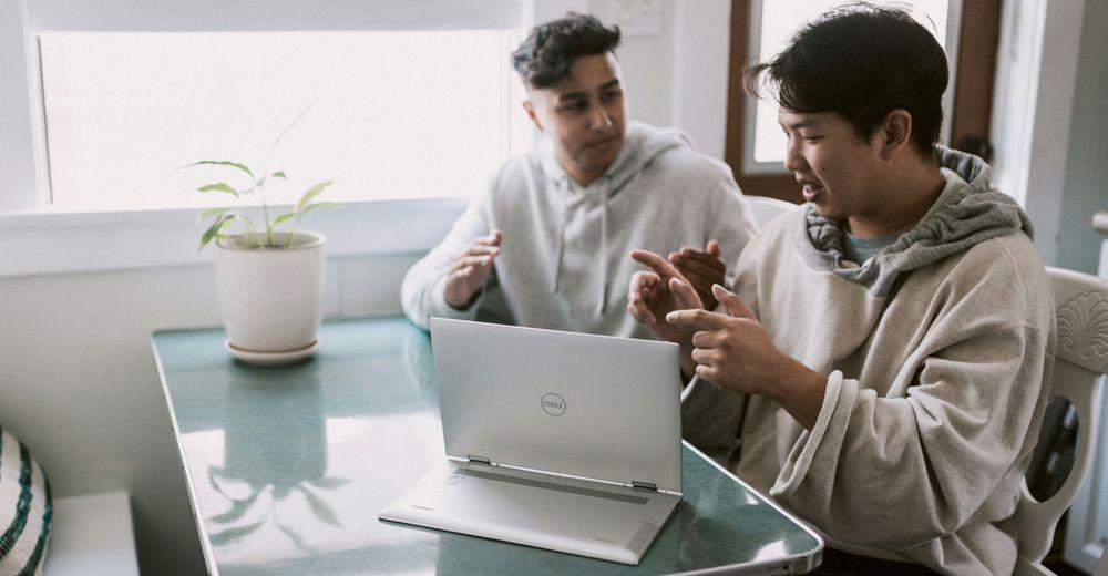 Dos amigos hablando mientras usan un equipo con Windows