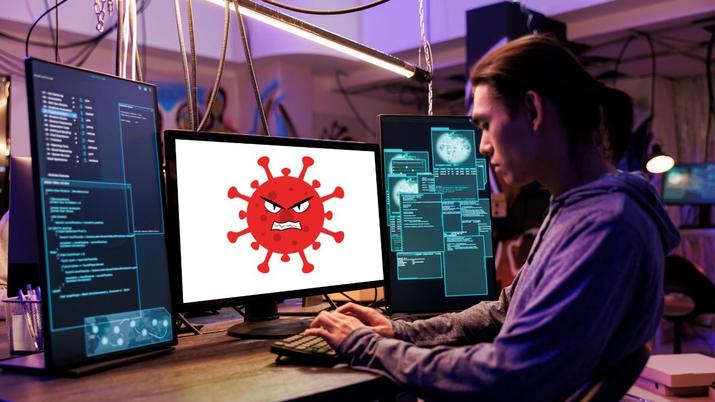 Un hacker con el icono de un virus en la pantalla del monitor