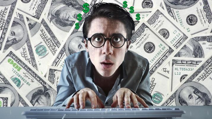 Un chico tecleando muy concentrado con una imagen de dinero de fondo