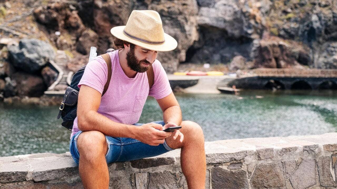 Un viajero se sienta mientras usa los datos de roaming